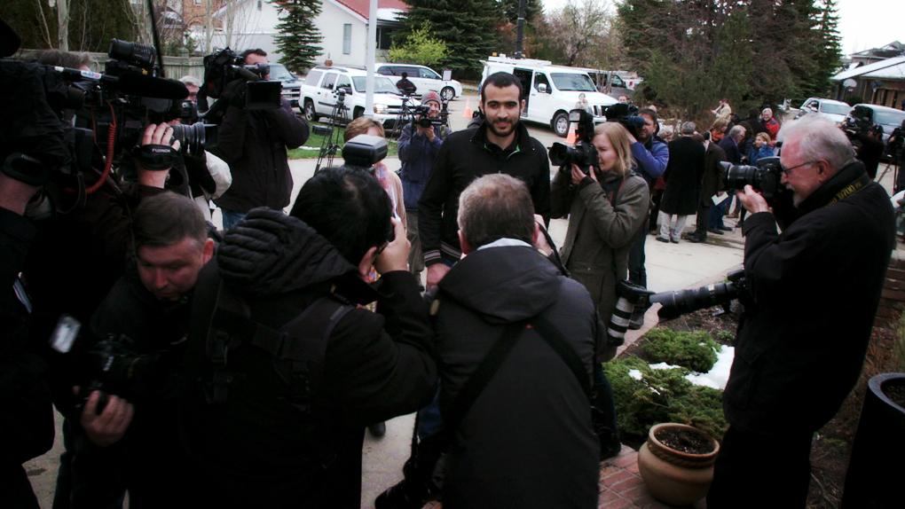 Omar Khadr, centre, talks to members of the media outside the Edmonton home of his lawyer Dennis Edney.